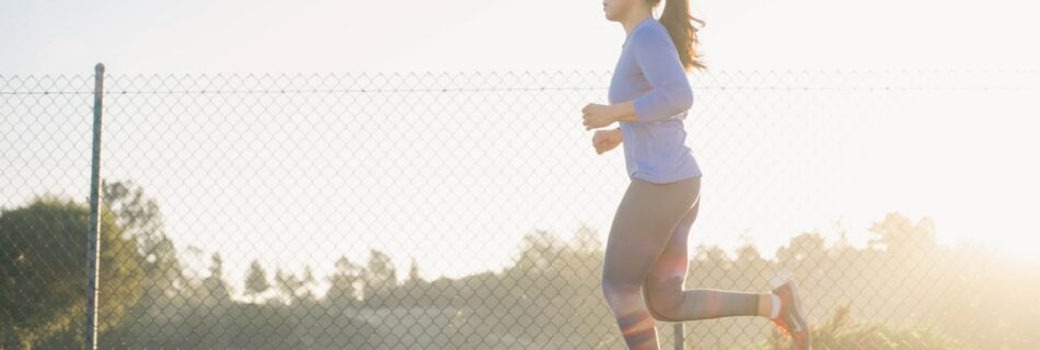 woman jogging near wire fence