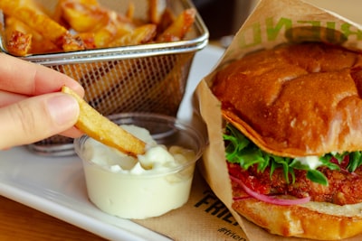 burger with cheese and vegetable on stainless steel tray